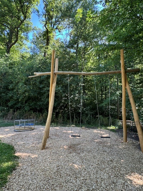 neuer Spielplatz der Naturfreunde Degerloch: im Vordergrund eine große Schaukel, im Hintergrund ein Karussell