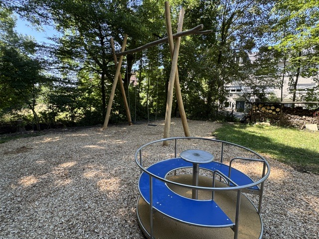 neuer Spielplatz der Naturfreunde Degerloch: im Vordergrund ein ein Karussell , im Hintergrund eine große Schaukel